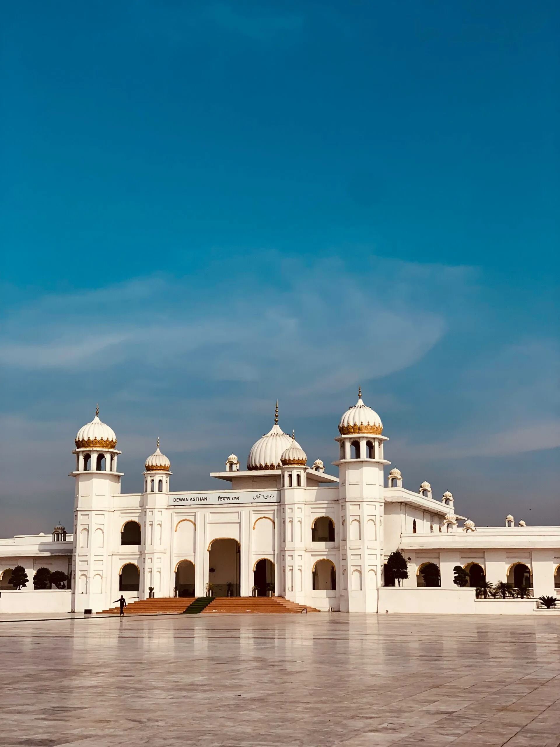 a large white building sitting on top of a cement field